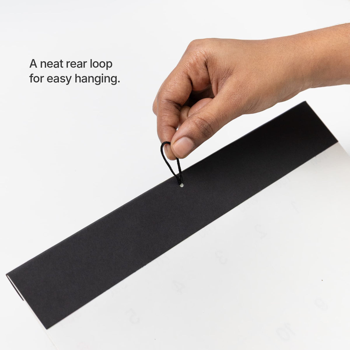 Hanging loop: Rear hanging loop on the black header of the Roda wall calendar.